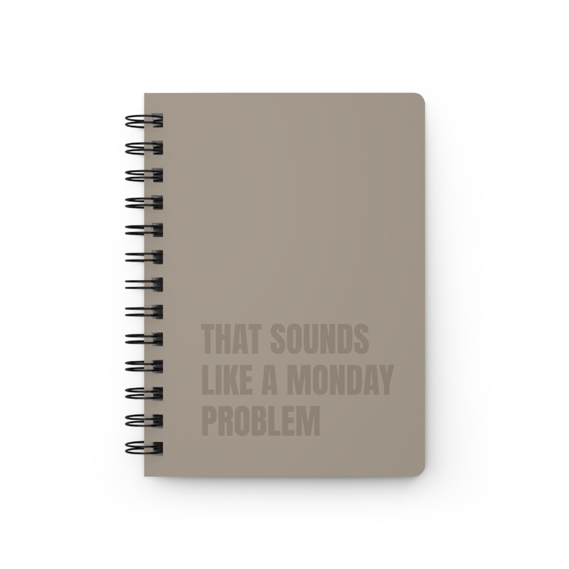 Beige notebook with text 'That sounds like a Monday problem' on a white background