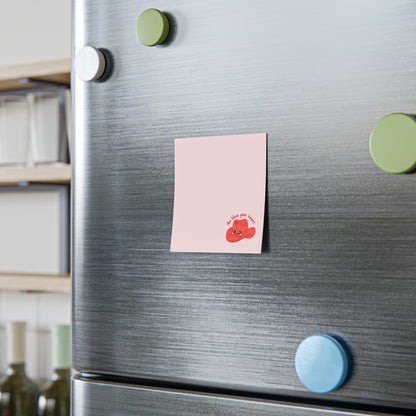 Pink sticky note with a small red cowboy hat character and the phrase “Aw bless your heart” printed at the bottom, attached to a stainless steel refrigerator door with colorful round magnets nearby.