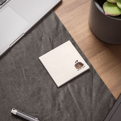 White business card with a logo on a gray textured surface next to a laptop and plant.