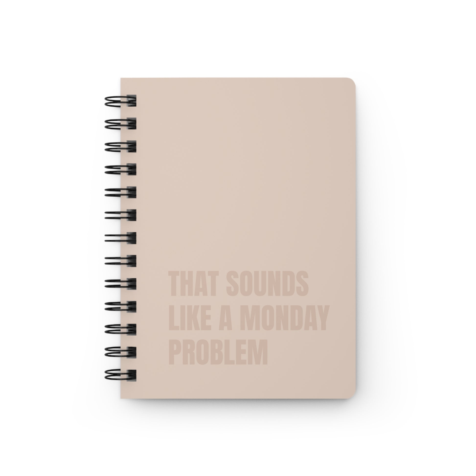 Beige notebook with text 'That sounds like a Monday problem' on a beige background