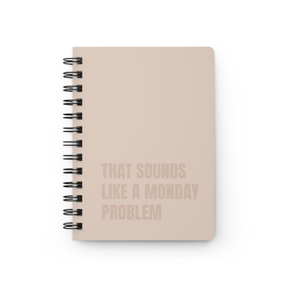 Beige notebook with text 'That sounds like a Monday problem' on a beige background