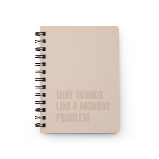 Beige notebook with text 'That sounds like a Monday problem' on a beige background