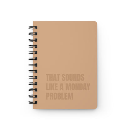 Notebook with text 'That sounds like a Monday problem' on a white background