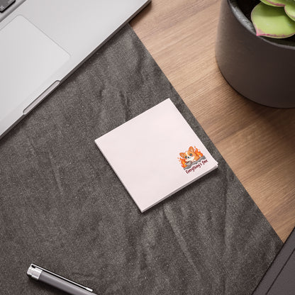 Notebook with a logo on a desk next to a laptop and plant