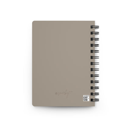 Beige notebook with spiral binding on a white background