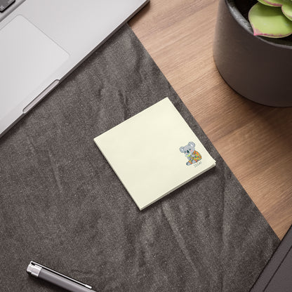 Notebook with a sticker on a desk next to a pen and plant