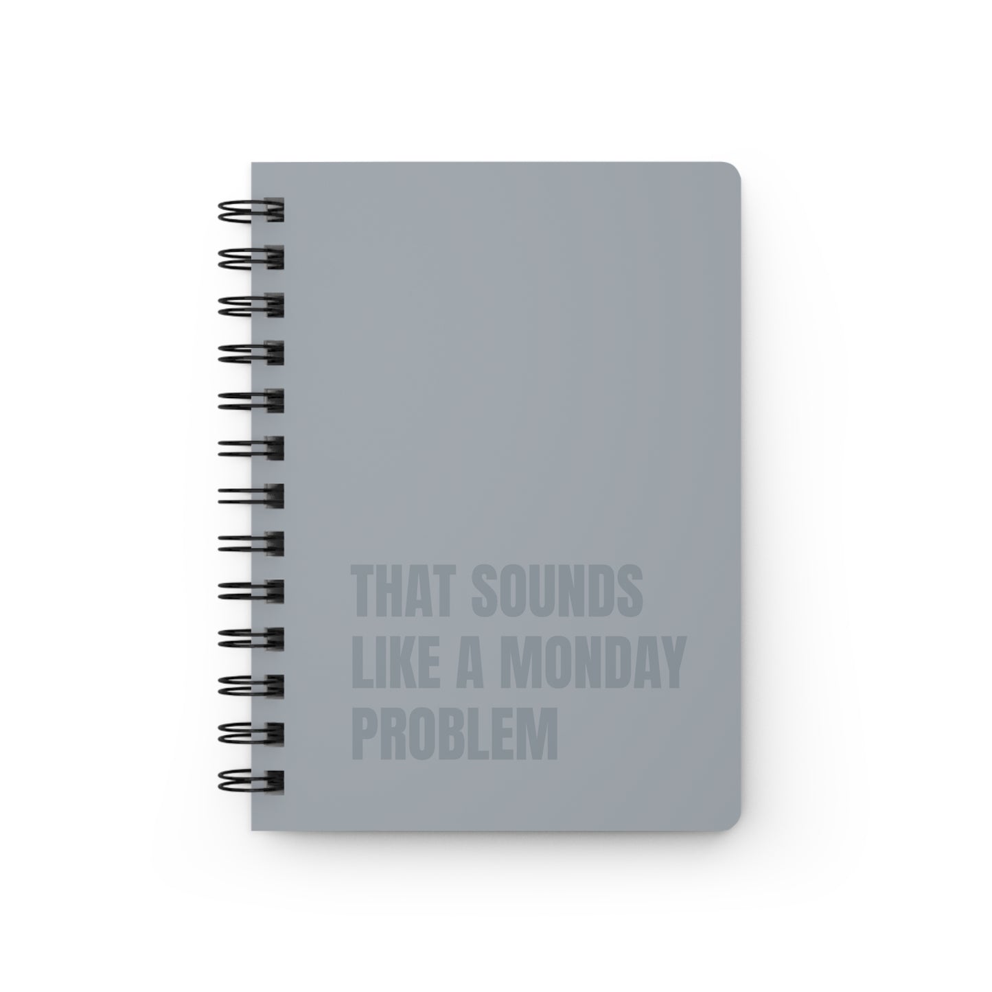 Gray notebook with text 'That sounds like a Monday problem' on a white background