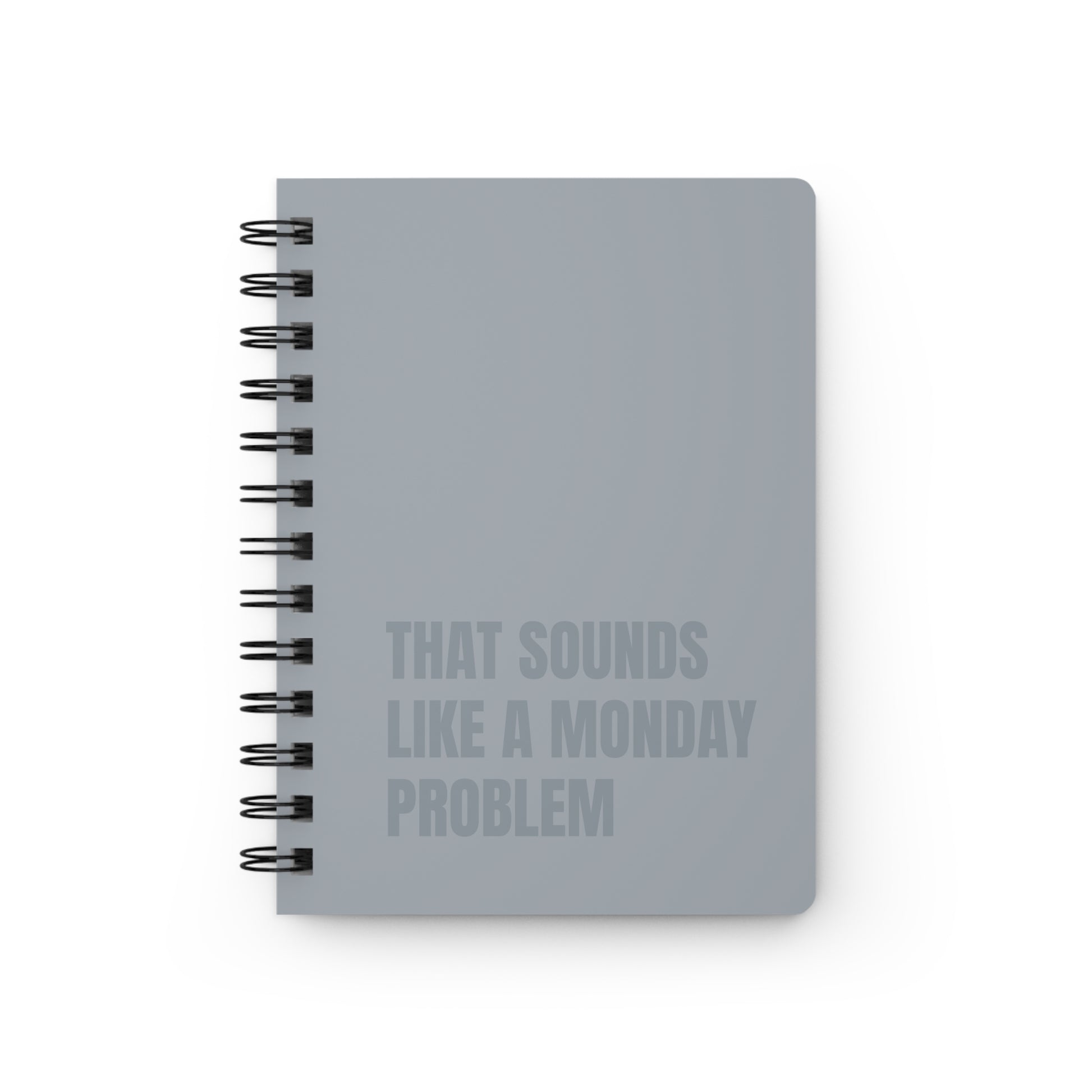 Gray notebook with text 'That sounds like a Monday problem' on a white background