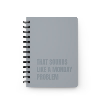 Gray notebook with text 'That sounds like a Monday problem' on a white background