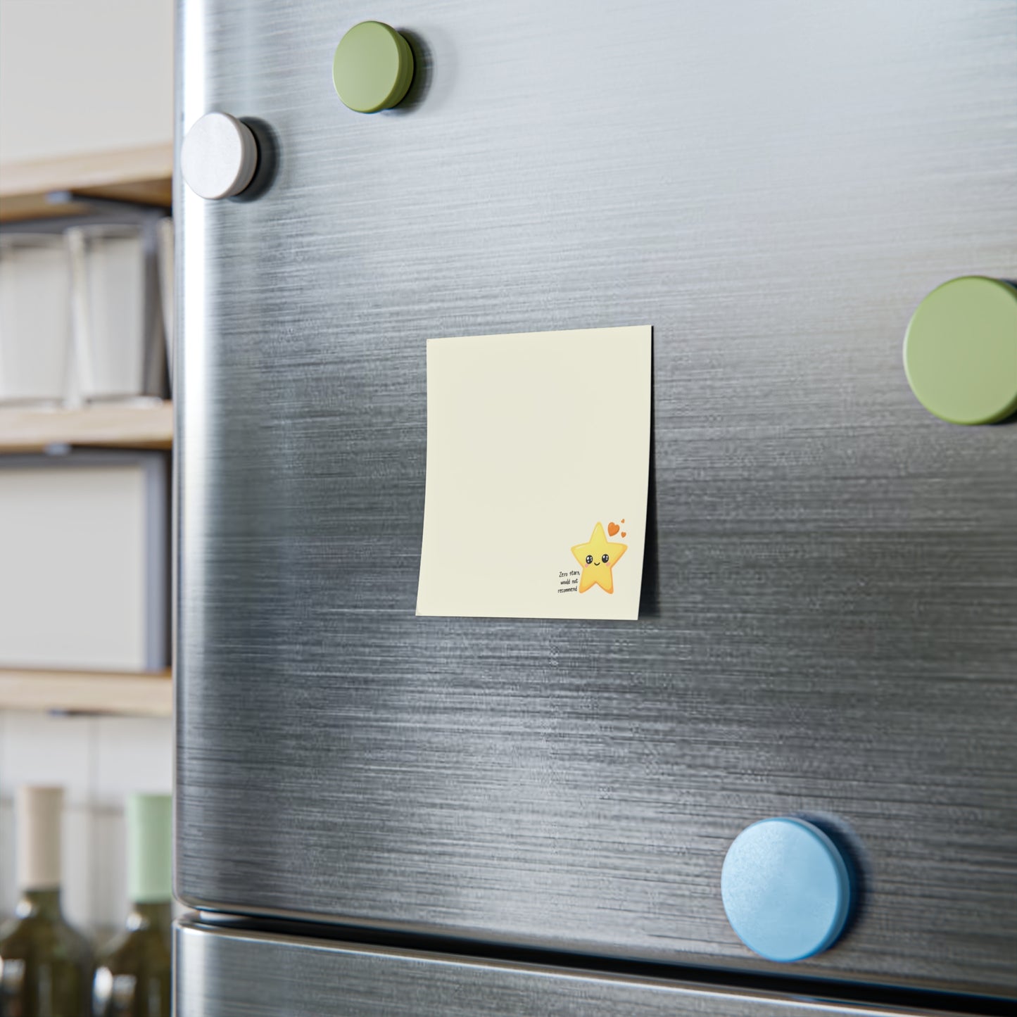 Square cream sticky note pad styled upright on a desk shelf with a small smiling star design in the lower corner.