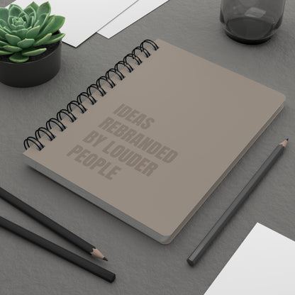 Notebook with text on a desk with pencils and a plant